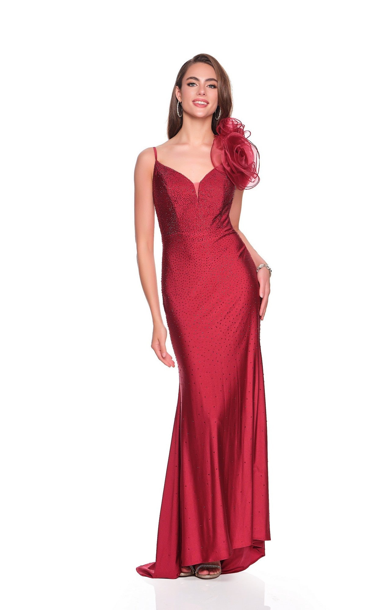 A woman models the Dave and Johnny 12412 long prom dress—burgundy, floor-length, fitted with rhinestones, a sweetheart neckline, thin straps, and 3D tulle floral applique on one shoulder—against a white backdrop.